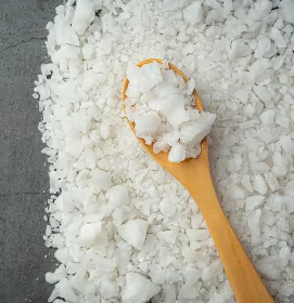 Cristaux blancs de MSM étalés autour d’une cuillère en bois